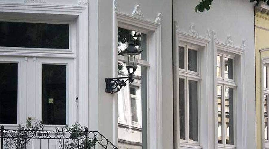 Sanierte Altbaufassade mit weißen Fensterrahmen